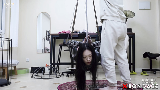 Peninsula Bondage - Sexy Asian Brunette Suspended In Latex